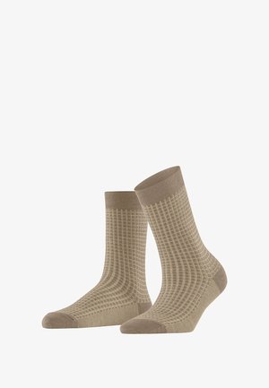 Chaussettes beiges avec un motif en grille texturé, une bordure côtelée et des accents de orteil et de talon unis. Fabriquées à partir d'un tissu doux et extensible.