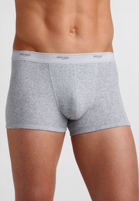 Boxer da uomo in cotone grigio con una morbida cintura elastica etichettata "sloggi", che presenta una vestibilità aderente e una superficie liscia.