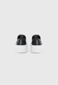 Zwarte leren sneakers met een witte rubberen zool, voorzien van een gestructureerd hieltab en een reliëflogo op de zijkant. Minimalistisch design.