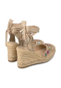 Beige espadrille-wedges met enkeltassen, geweven jute zolen, bovenwerk van suede en versierd met kleurrijke bloemenbeading aan de voorkant.