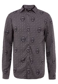Camicia nera a manica lunga caratterizzata da un motivo geometrico a diamante con contrasti di teschi bianchi. Chiusura frontale con bottoni, design con colletto classico.