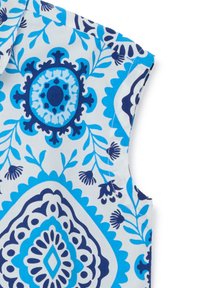 Top senza maniche con un motivo floreale blu e bianco, caratterizzato da disegni intricati e contrasti di tonalità blu. Tessuto in cotone morbido.
