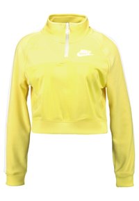 Gul kort sweatshirt med hög krage, halvdragkedja och vit Nike-logga. Har långa ärmar med vita sidostripes och ribbade muddar.
