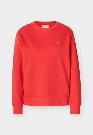 Sweat-shirt rouge à manches longues avec col ras-du-cou, petit logo brodé blanc et bleu sur le côté gauche de la poitrine, poignets et ourlet côtelés.