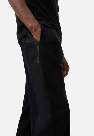 Sorte fleece bukser med slanke sideskydere, der har en kombination af tekstureret og glat stof for en behagelig pasform.