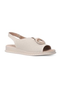 Beige perforierte Leder-Slingback-Sandale mit offenem Zehenbereich, rundem Akzentdetail und flacher Gummisohle.
