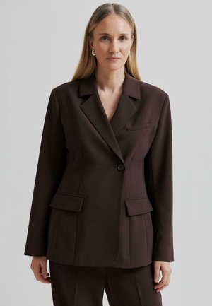 Donkerbruin op maat gemaakte blazer met een gelapte revers, enkele knopen sluiting en twee voorkeurszakken. Gladde textuur met een gestructureerde pasvorm.