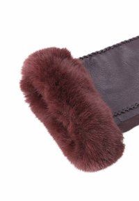 Guanto di pelle marrone con bordo in pelliccia spessa e morbida di un rosso scuro al polso, presentato su uno sfondo bianco.