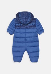 Niebieski, ocieplany kombinezon dla niemowląt z kapturem, z ciemnoniebieską, wzorzystą wstawką i logo Timberland z tyłu.