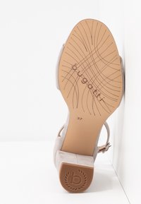 Semelle de chaussure avec logo "bugatti", taille 37, semelle extérieure marron clair avec rainures à motifs et talon bloc avec logo "b" embossé.