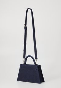 Mørkeblå håndtaske med et struktureret design, der har et topgreb og en aftagelig skulderrem, sat mod en lys baggrund.