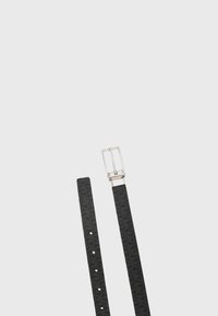 Ceinture en cuir noir avec un motif texturé subtil et une boucle rectangulaire en argent, posée à plat sur un fond clair uni.