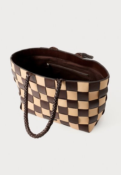 Brun og beige ternet tote-agtig taske med flettede håndtag, åben top der viser en mørk indvendig og en lynlås lomme indeni.