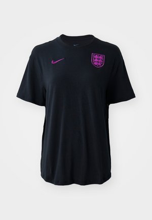 Czarny T-shirt z krótkim rękawem wykonany z miękkiego materiału. Na piersi znajduje się fioletowe logo Nike oraz herb z trzema lwami. Prosty krój.