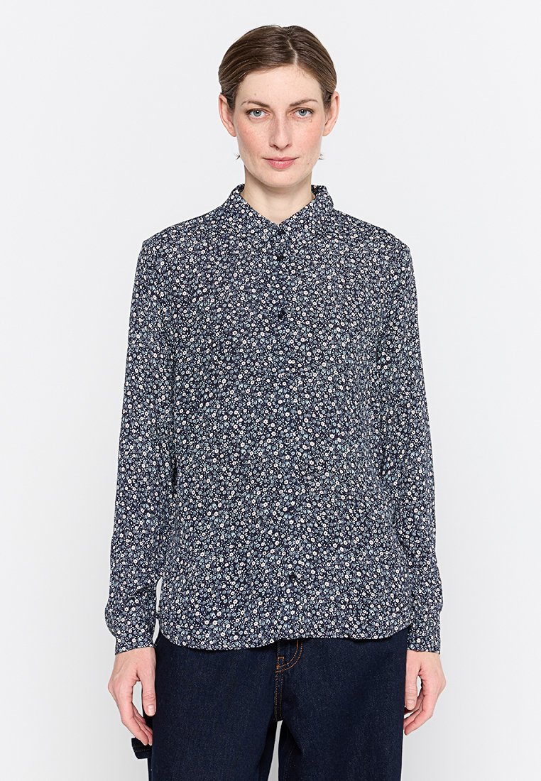 Marineblouse met een klein wit en roze bloemmotief, lange mouwen, knoopsluiting aan de voorkant en een puntkraag. Zachte stofstructuur.