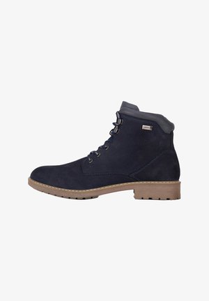 Tamsiai mėlynos spalvos aulinukas iš zomšos medžiagos, apvalios nosies, su raišteliais ir kontrastingu smėlio spalvos guminiu padu su sukibimo raštu.