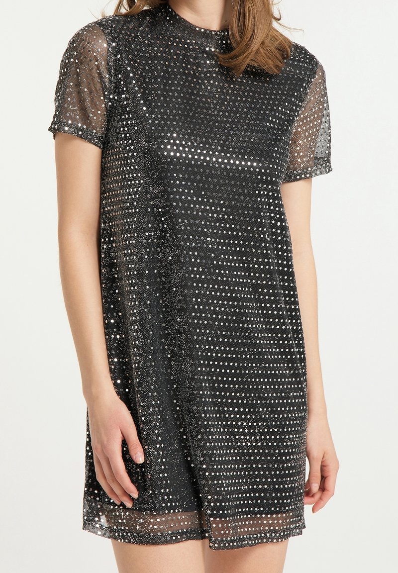 Svart klänning med korta ärmar, gjord av genomskinligt material, täckt av silverfärgade paljetter, med rund halsringning och en avslappnad passform.