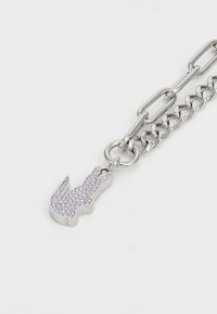 Chaîne en argent avec un pendentif en forme de lapin en strass violet. Le pendentif présente une silhouette détaillée avec une finition lisse et des accents brillants.