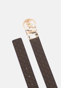 Ceinture en cuir marron à motif avec une texture lisse, dotée d'une boucle circulaire dorée avec un logo. Ajustable grâce à plusieurs trous pour un meilleur ajustement.