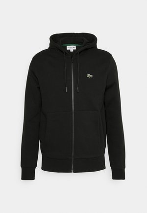Sweat à capuche noir zippé avec poches avant, cordon à la capuche et petit logo crocodile vert sur la poitrine gauche.