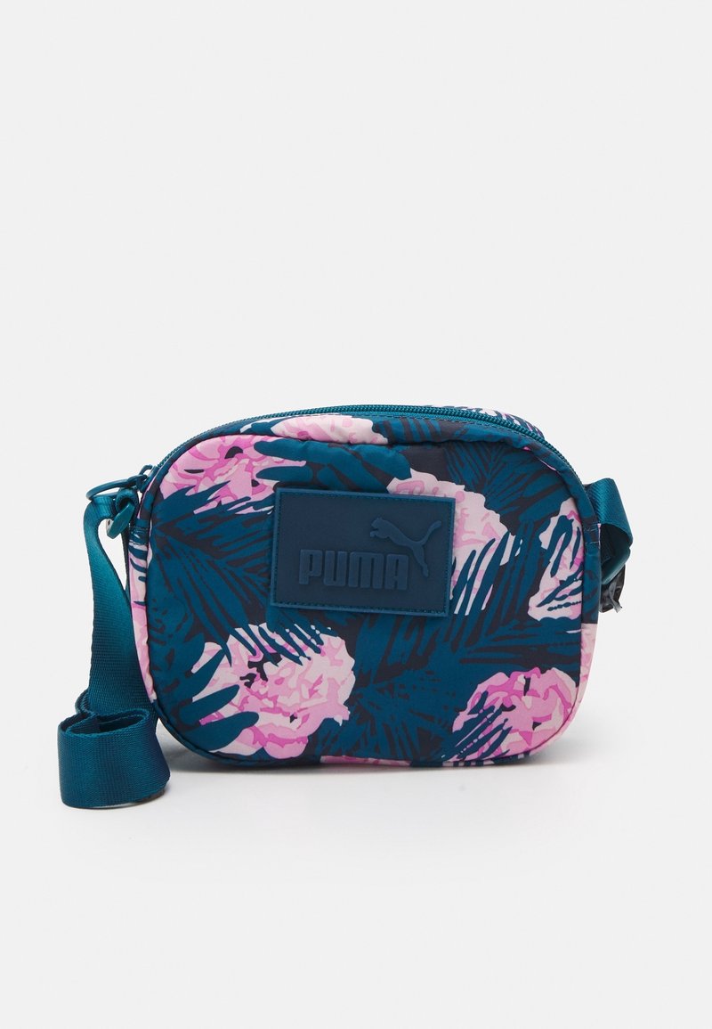 Vibrant floral print bag with pink and teal colors, rectangular shape, zip closure, adjustable strap, and Puma logo detail.