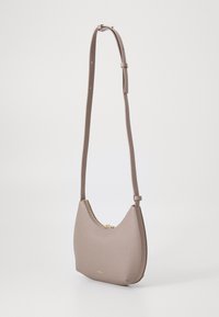 Borsa a spalla in ecopelle marrone con forma curva, chiusura a zip, tracolla regolabile e sottili accenti dorati.