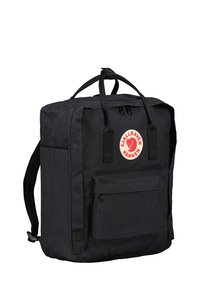 Sac à dos Fjällräven Kånken en noir, de forme rectangulaire, fabriqué à partir de matériaux durables, comportant une poche avant et un patch logo circulaire.