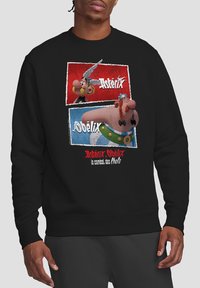 Black sweatshirt featuring a graphic of Asterix and Obelix on a printed background with red and blue panels, text in white and red.