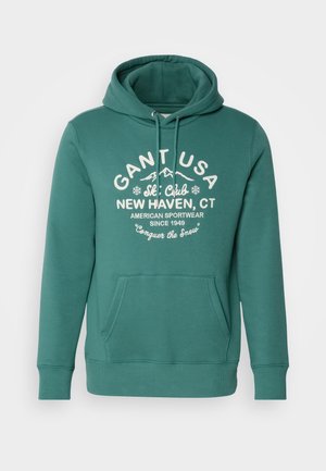 Green hoodie made of soft material, featuring a front pocket, drawstring hood, and white text with ski club logo and details.