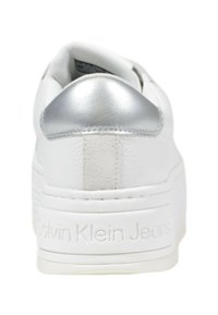 Sneaker bianca con una tomaia in pelle liscia, dettaglio argento sul tallone, pannello posteriore testurizzato e logo in rilievo sulla suola.