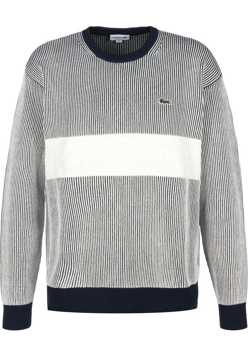 Gestreifter Strickpullover in Marineblau und Weiß, mit einem auffälligen weißen horizontalen Band, auf dem der eingeprägte Text "LACOSTE" und ein kleines Logo zu sehen sind.