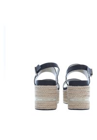 Sandalias de plataforma de cuero negro con suela intermedia de yute trenzado, correa para el tobillo ajustable y un ligero acento de logo en la suela.
