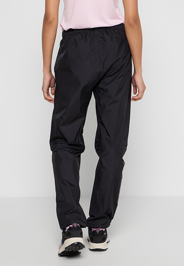 Mustat vedenpitävät housut, joissa on joustava vyötärö, kapenevat lahkeet ja sivuraidat, valmistettu kevyestä kankaasta ja joissa on sileä pinta.