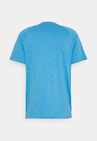 Camiseta de manga corta en azul claro, hecha de un tejido transpirable; cuenta con un cuello redondo y una textura suave sin adornos.