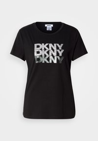 T-shirt in cotone nero con grande logo "DKNY" in argento metallico e glitterato stampato sul davanti. Design a maniche corte e collo rotondo.