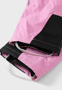 Giacca rosa e nera in tessuto liscio. Presenta polsini elastici, un design pieghevole e cuciture evidenziate in rosa.
