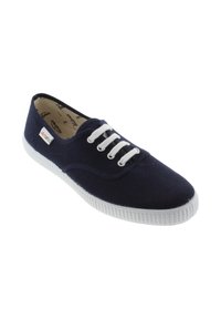 Sneaker di tela blu navy con suola in gomma bianca, lacci bianchi e un piccolo tag "victoria" sul lato.