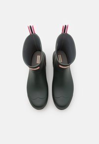 Green rubber ankle boots with a low gloss finish, a rounded toe, and a striped pull tab. Interior lined in soft gray material with logo.
