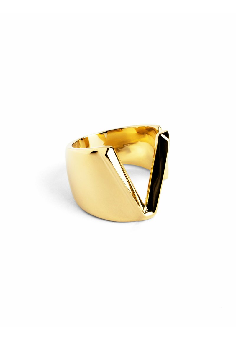 Anello in metallo dorato con design a forma di V ritagliato. Finitura liscia e lucida con una banda curva e un profilo geometrico audace.