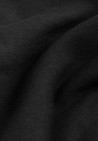 Tessuto nero con una superficie liscia e strutturata, caratterizzato da sottili ribattiture uniformemente distanziate. Il materiale appare elastico e leggero.