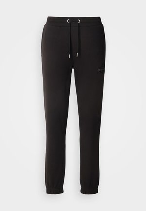 Pantalones de chándal negros de algodón con cintura elástica, cordón y puños acanalados. Presentan un logo sutil bordado en el lateral.