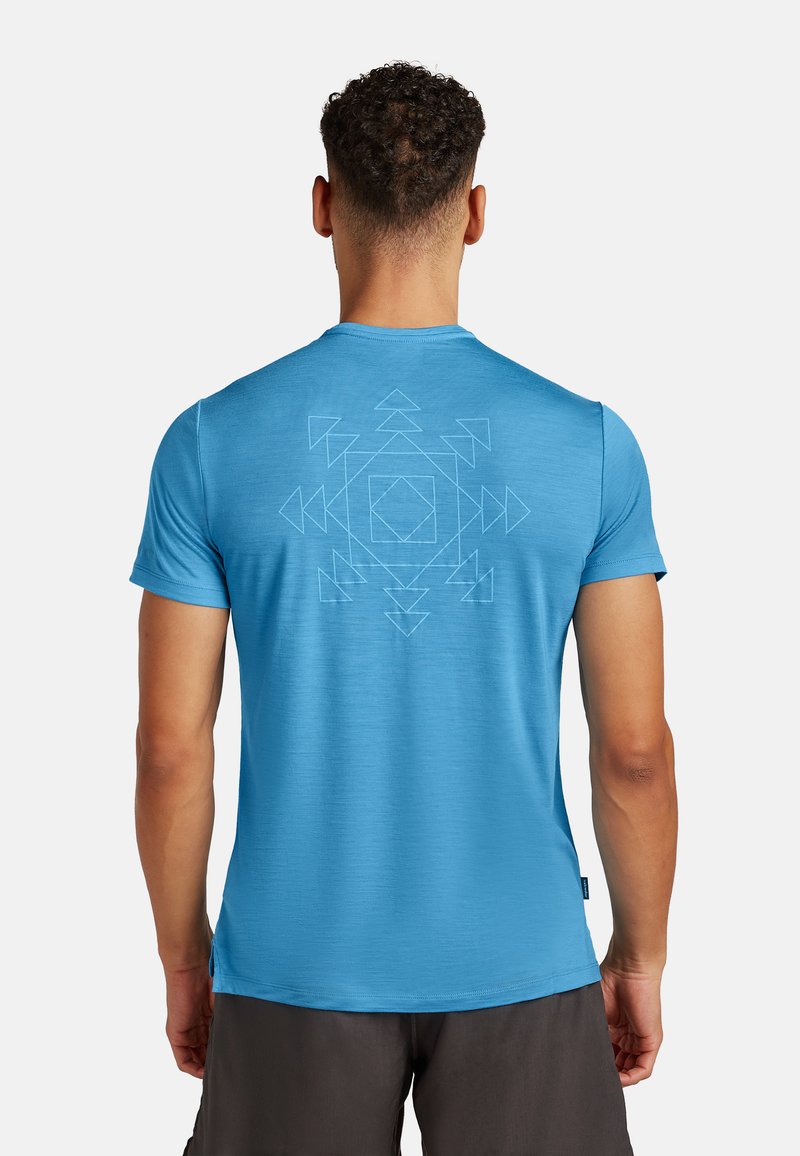 Lys blå t-shirt med korte ærmer og en glat tekstur, der har et geometrisk mønster i en lysere nuance på bagsiden.