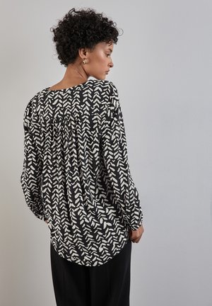 Zwarte blouse met wit abstract patroon, lichtgewicht stof, losse pasvorm, ronde halslijn, geplooide achterkant, lange mouwen.