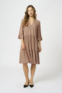 Rochie roz până la genunchi cu un design în straturi, mâneci 3/4, decolteu în V și model cu buline negre; asortată cu pantofi plate ascuțiți negri.