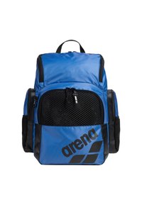 Mochila deportiva azul con un bolsillo frontal de malla, acentos en negro y logo. Presenta múltiples compartimentos y correas de hombro acolchadas.