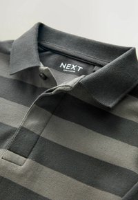 Polo T-shirt med vandrette striber i nuancer af grå. Lavet af tekstureret stof med krave og knapdetalje. Mærkets label synlig.