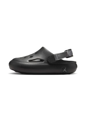 Svart slip-on sandal i gummi med en strukturerad hälrem, ventilationshål och en cirkulär logodetalj på sidan.