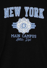 Fekete pamut póló kék felirattal. A design tartalmazza a "NEW YORK" feliratot, egy kör alakú címert és a "MAIN CAMPUS" szöveget texturált felülettel.