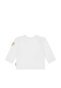 Witte lange mouwen shirt met een ronde kraag en een klein geborduurd dierenpatch op de linkermouw. Zacht katoenmateriaal.