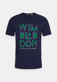 Marinblå bomullströja med stort "WIMBLE" och "DON" text i grönt och lila, med en liten logotyp ovanför varumärket i botten.